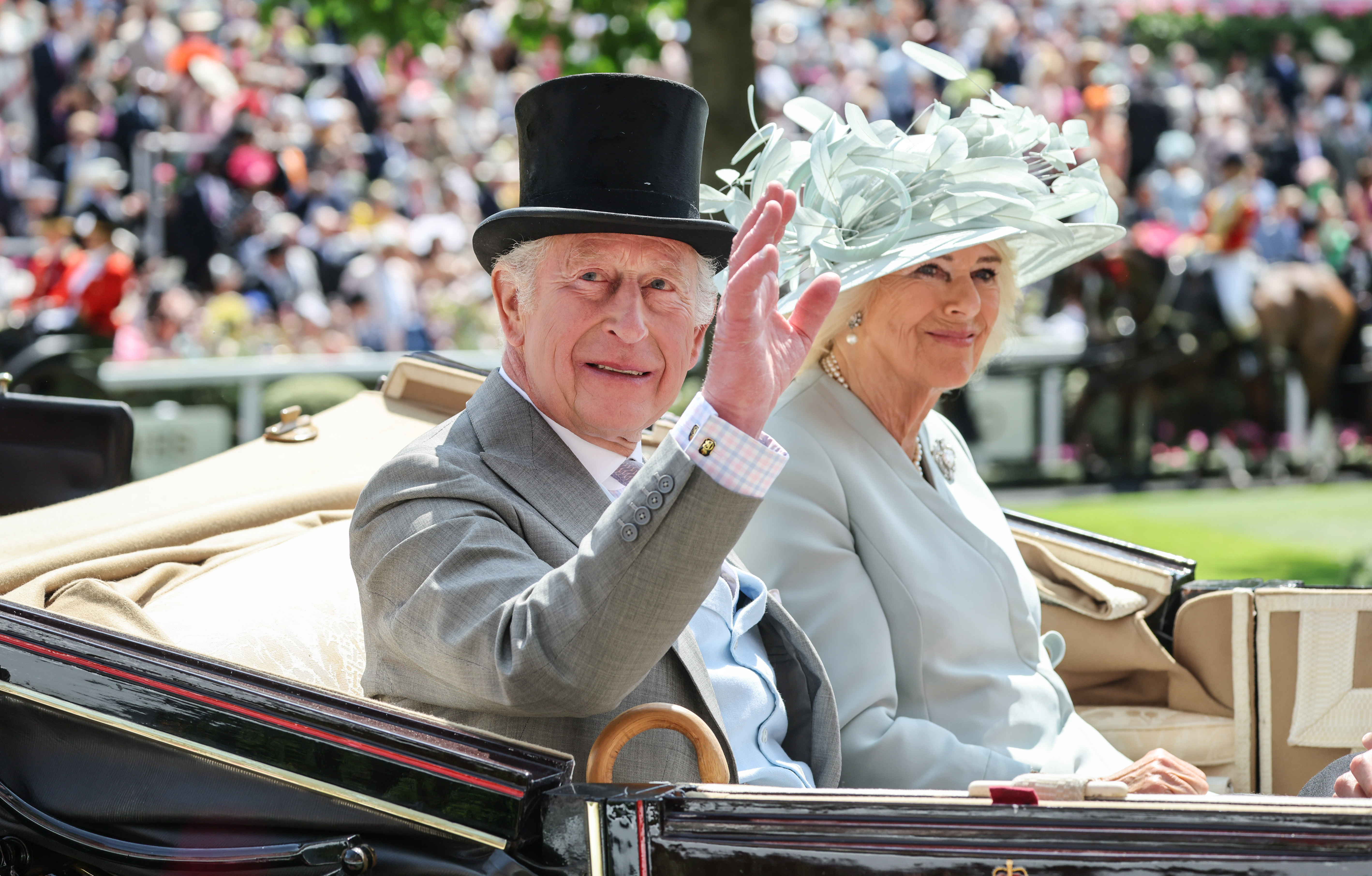 The King and Queen arrive at Ascot race course in a carriage.
