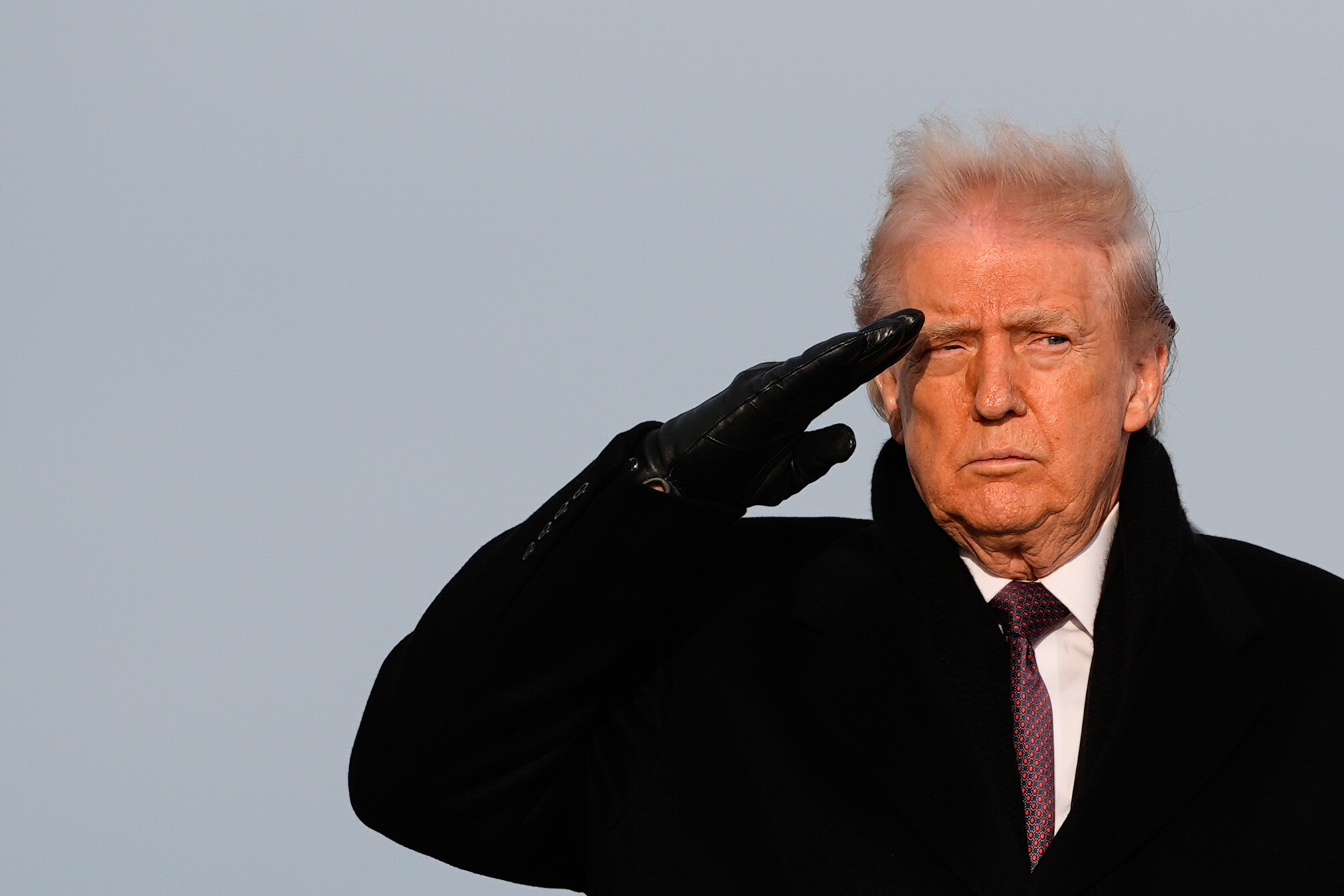 President Donald Trump salutes during a casualty return at Dover Air Force Base.