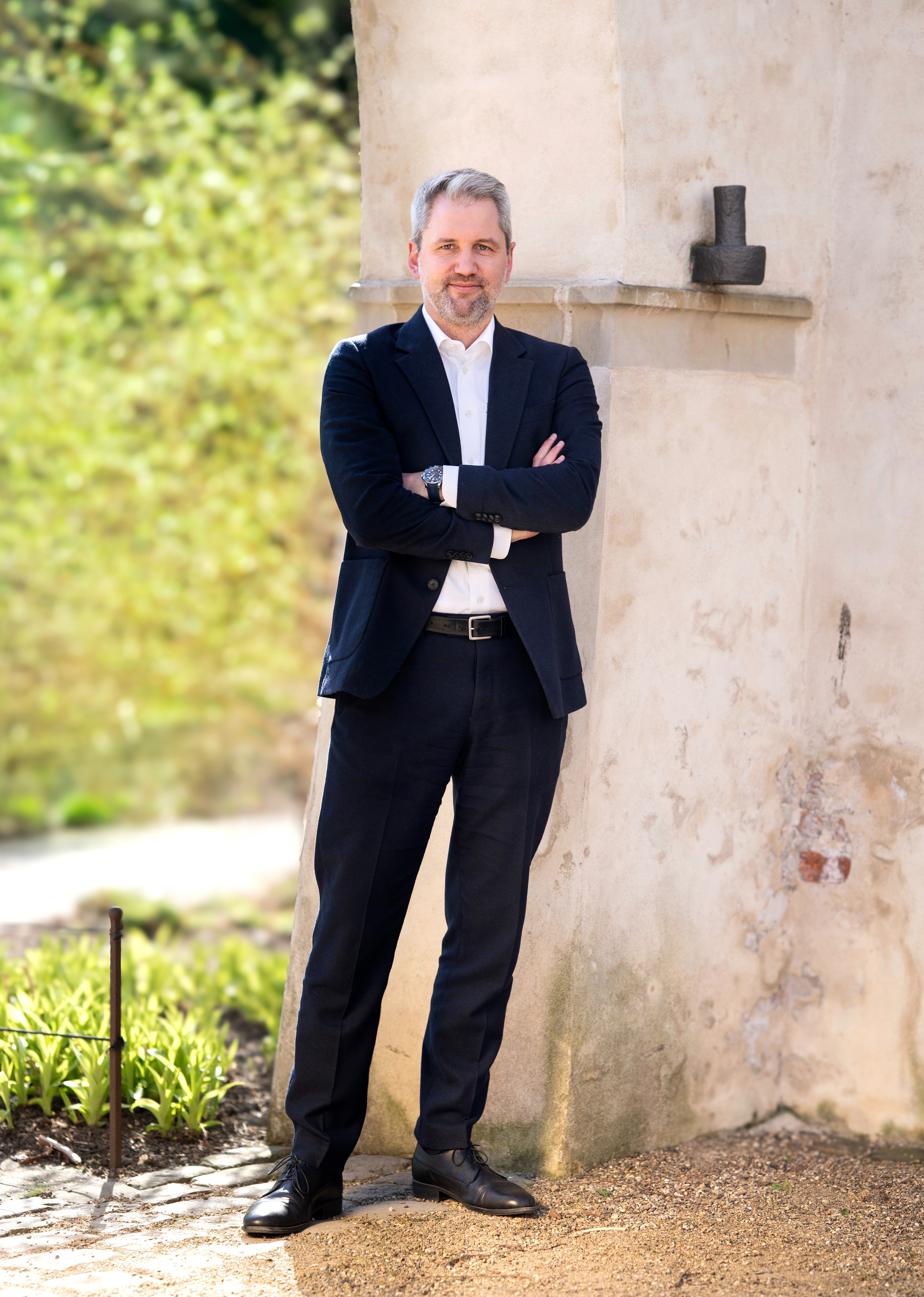 Jesper Østergaard Bocianski standing with arms crossed next to a wall.