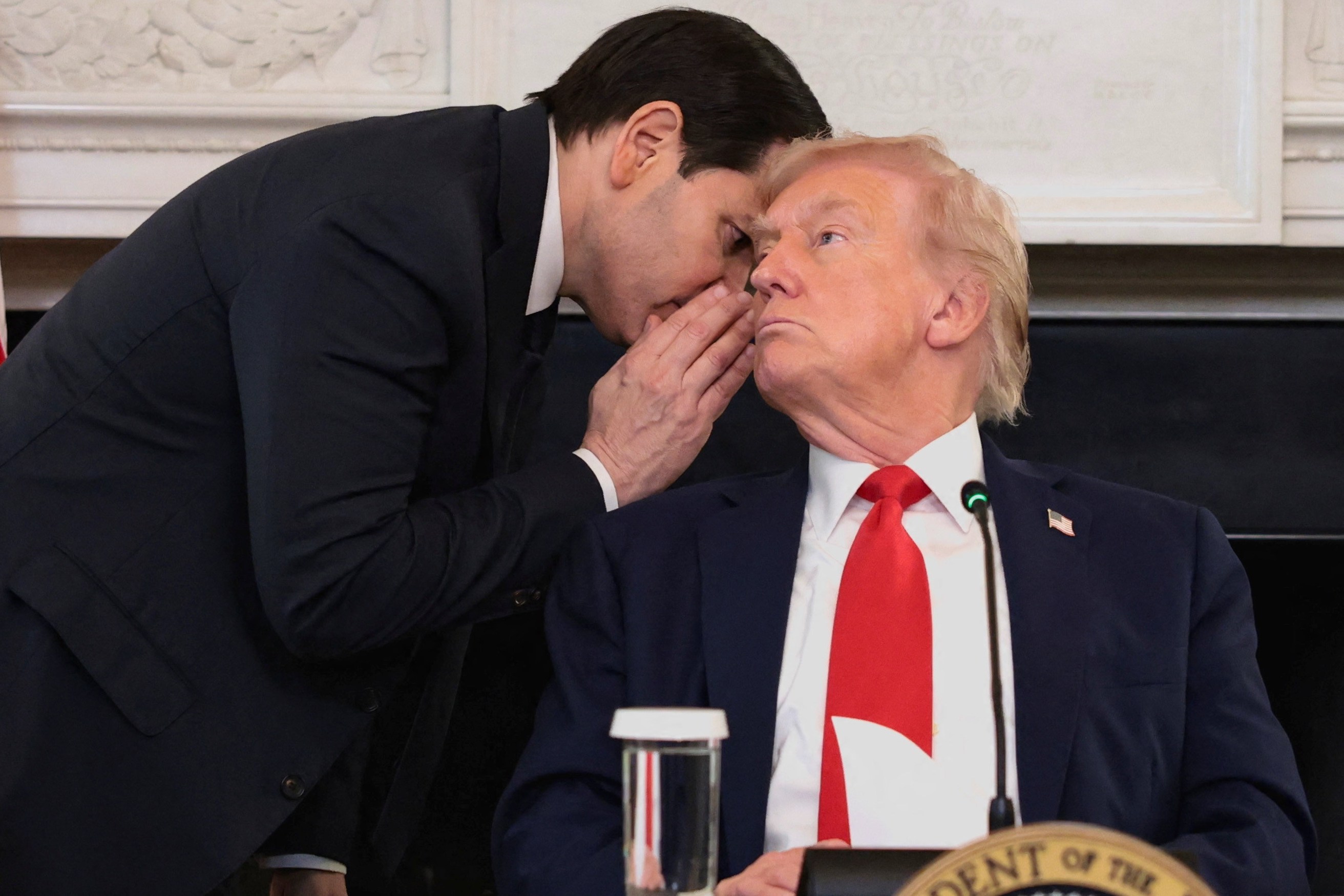 Secretary of State Marco Rubio whispers to President Donald Trump during a roundtable discussion.