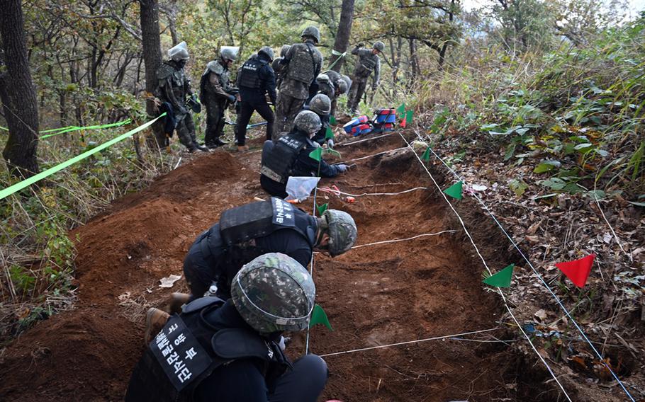 South Korean troops excavate the dirt looking for war remains.