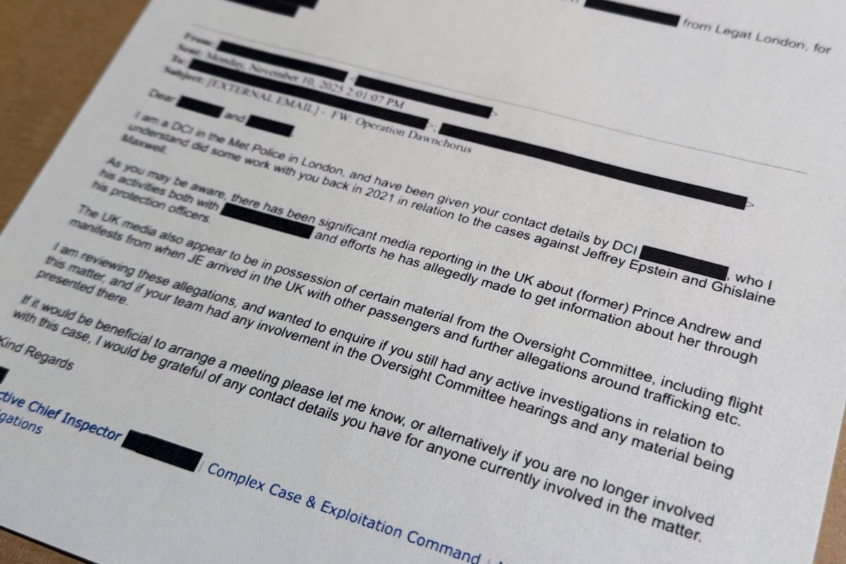 A document featuring a structured layout with text in black ink on a white page, placed on a wooden surface. The text appears to be a formal document, possibly a legal or business form, with several sections filled in.