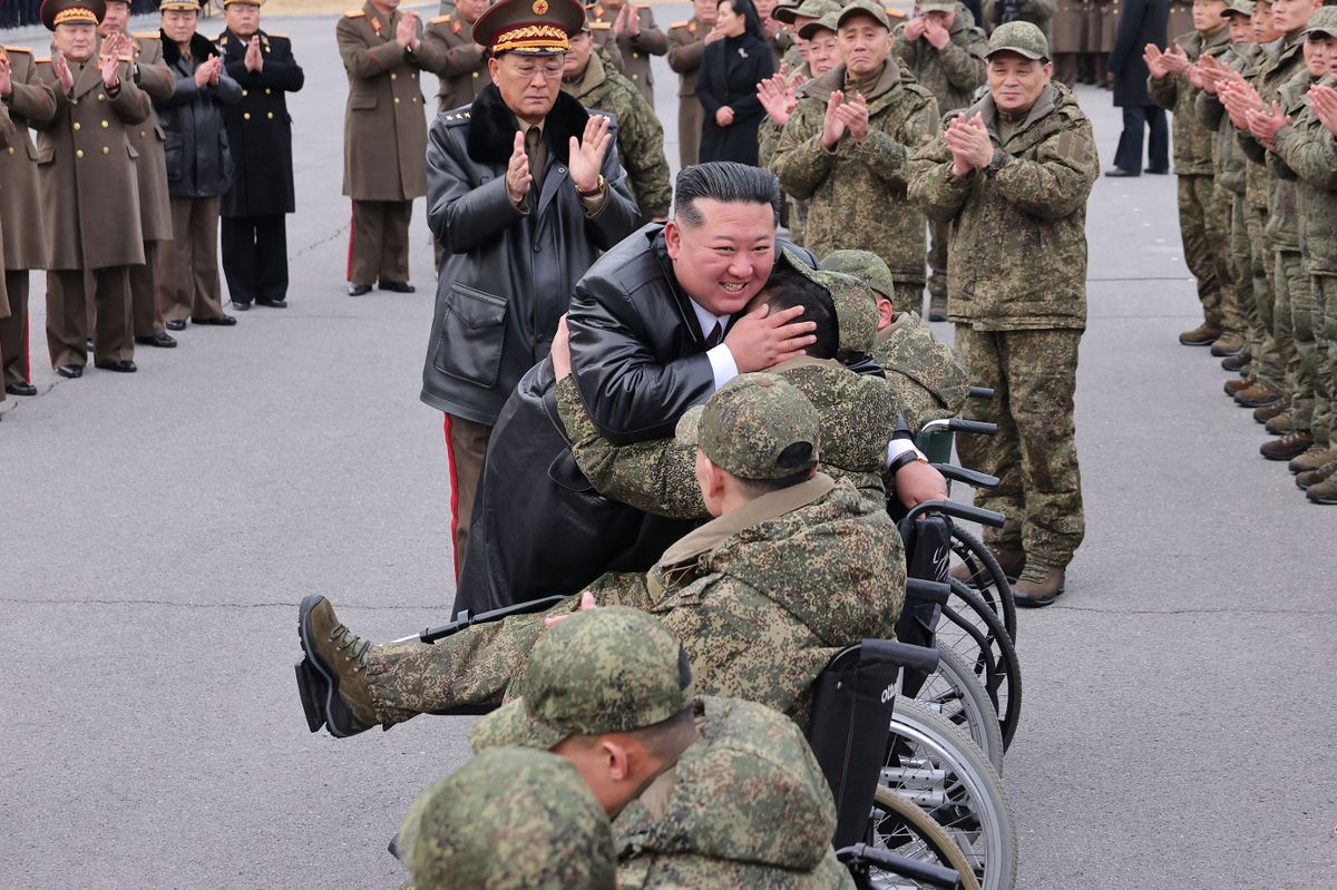 Kim hugging a soldier in a wheelchair