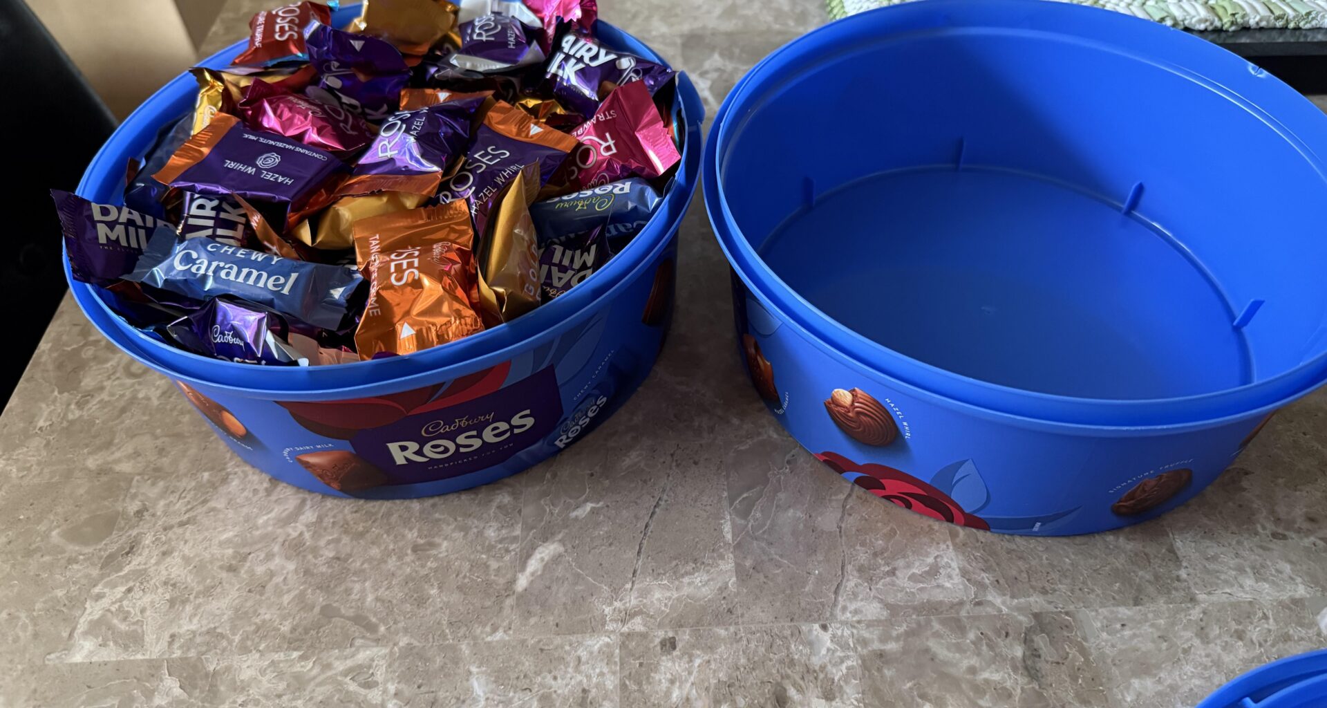 Two tubs of Cadbury Roses fits into one, and yes the lid closed perfectly on it.