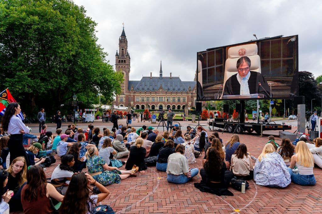 People watch the live stream of the ICJ advisory opinion delivery outside of the Peace Palace in The Hague on July 23, 2025.