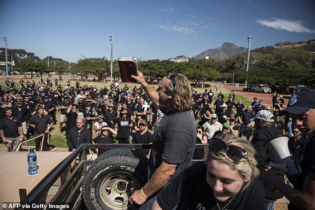 A protester holds a bible as he speaks to South African farmers & farm workers gathered at a demonstration at the Green Point stadium to protest against farmer murders in the country, on October 30, 2017, in Cape Town