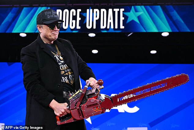 Elon Musk holds a chainsaw reading "Long live freedom, damn it" during the annual Conservative Political Action Conference (CPAC) at the Gaylord National Resort & Convention Center at National Harbor in Oxon Hill, Maryland, on February 20, 2025.