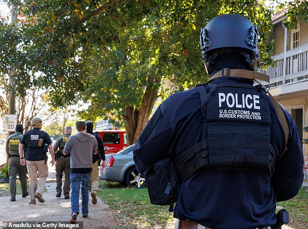 Customs and Border Patrol agents walk through a residential neighborhood in Kenner, New Orleans on December 10 as part of Operation Catahoula Crunch