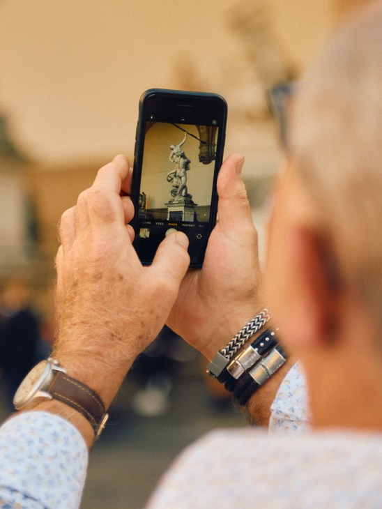 A tourist snaps a photo of a statue in Florence