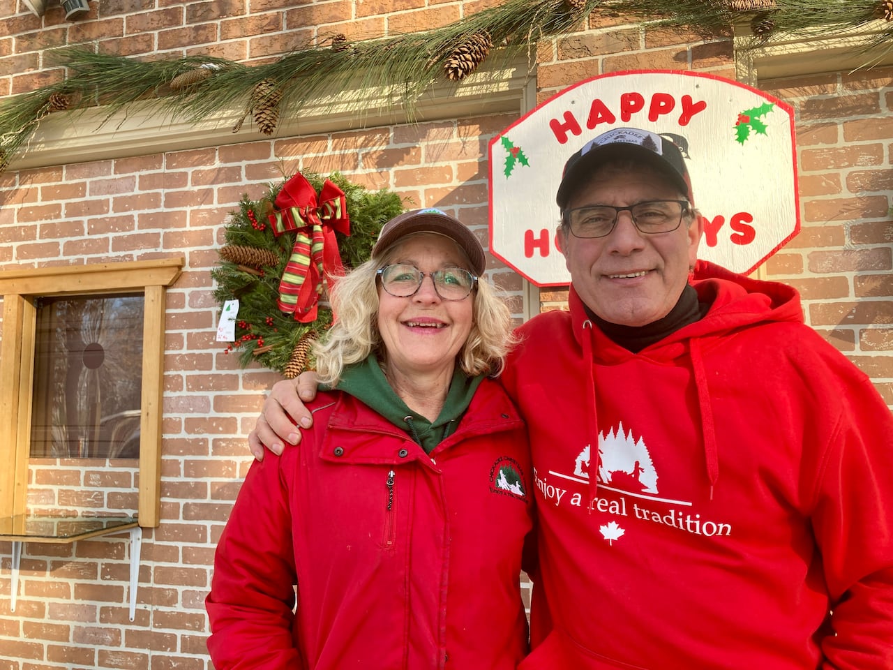 A man and a woman stand smiling at the camera.