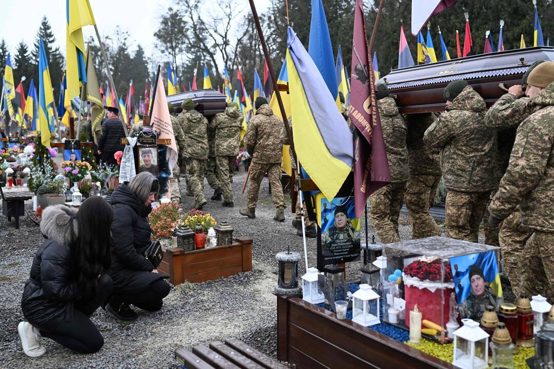 Deux femmes s'agenouillent au passage des cercueils des soldats Marian Maksymiv et Andriy Dobryansky dans le cimetière militaire de Lychakiv, à Lviv (ouest de l'Ukraine), le 3 décembre 2025. — © SERGEI GAPON / AFP Deux femmes s'agenouillent au passage des cercueils des soldats Marian Maksymiv et Andriy Dobryansky dans le cimetière militaire de Lychakiv, à Lviv (ouest de l'Ukraine), le 3 décembre 2025. — © SERGEI GAPON / AFP
