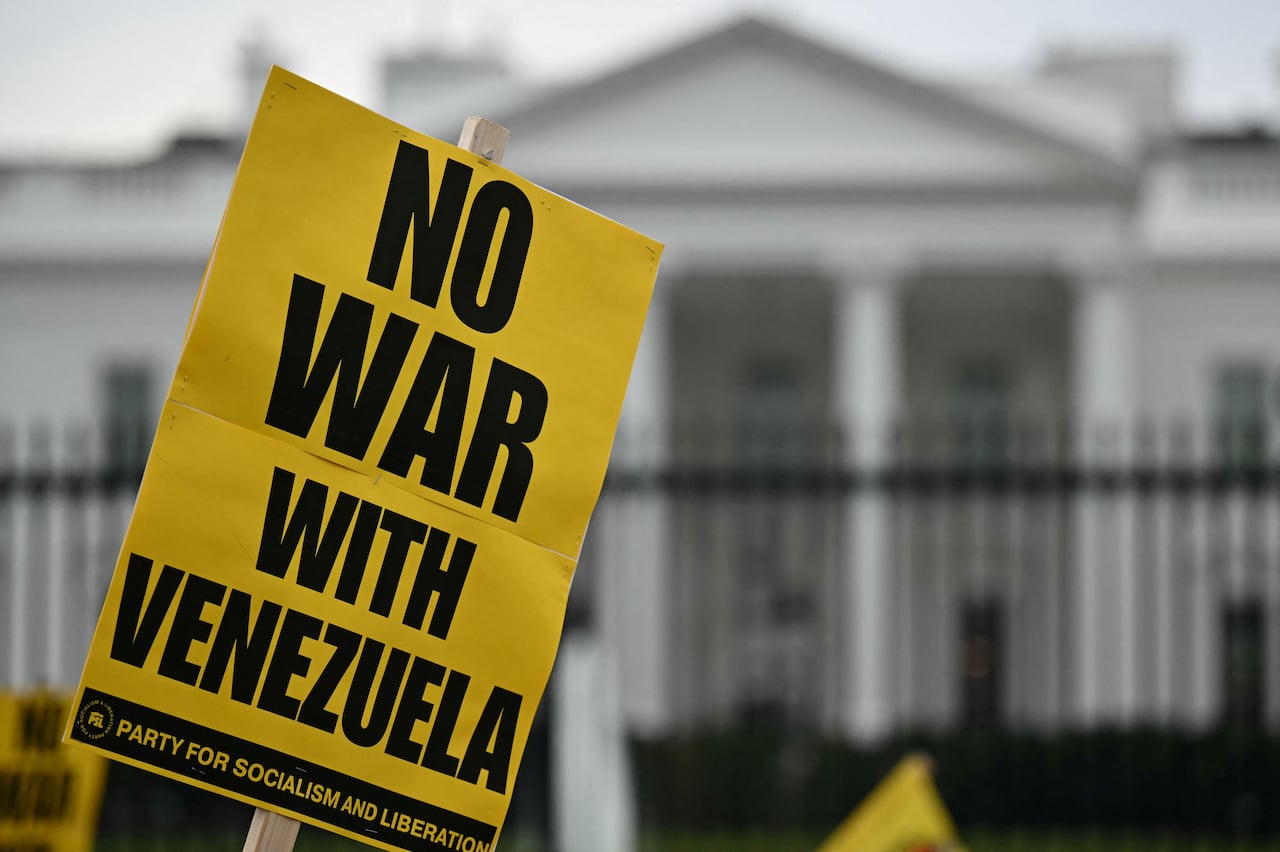 A placard opposing U.S. intervention in Venezuela is seen being held aloft outside the White House