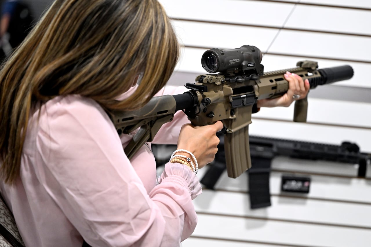 A person looks down the sights of a rifle at an exhibition.