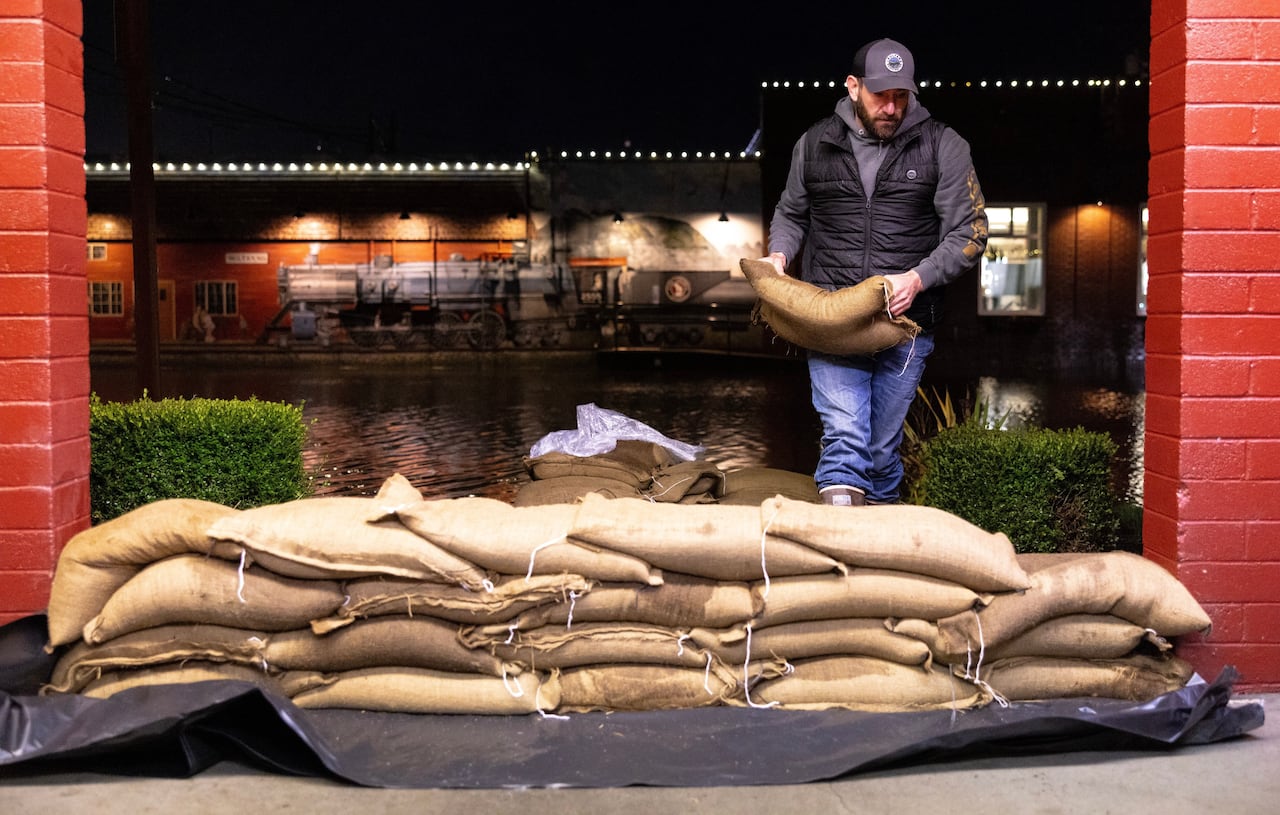 A man stacks sand bags.