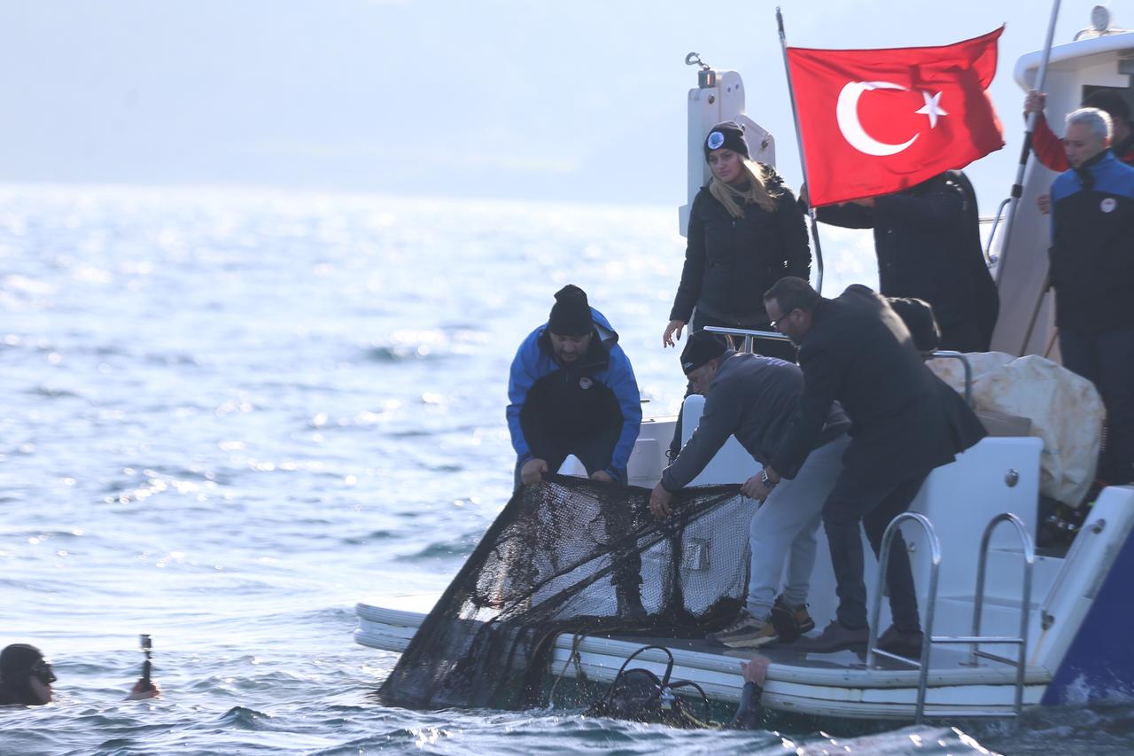Divers and officials haul a ghost net onto the Fisheries Control boat during a cleanup operation off Kumkale, Canakkale, Türkiye, Dec. 11, 2025. (AA Photo)
