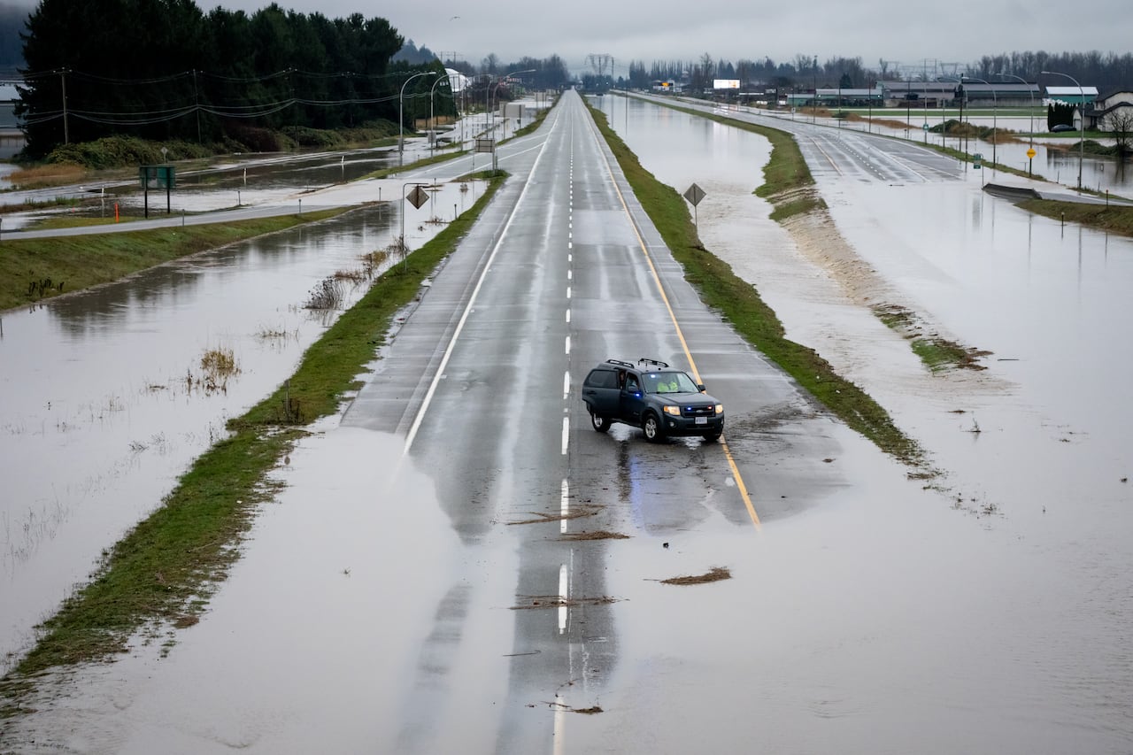 A police car drives down a flooded Highway