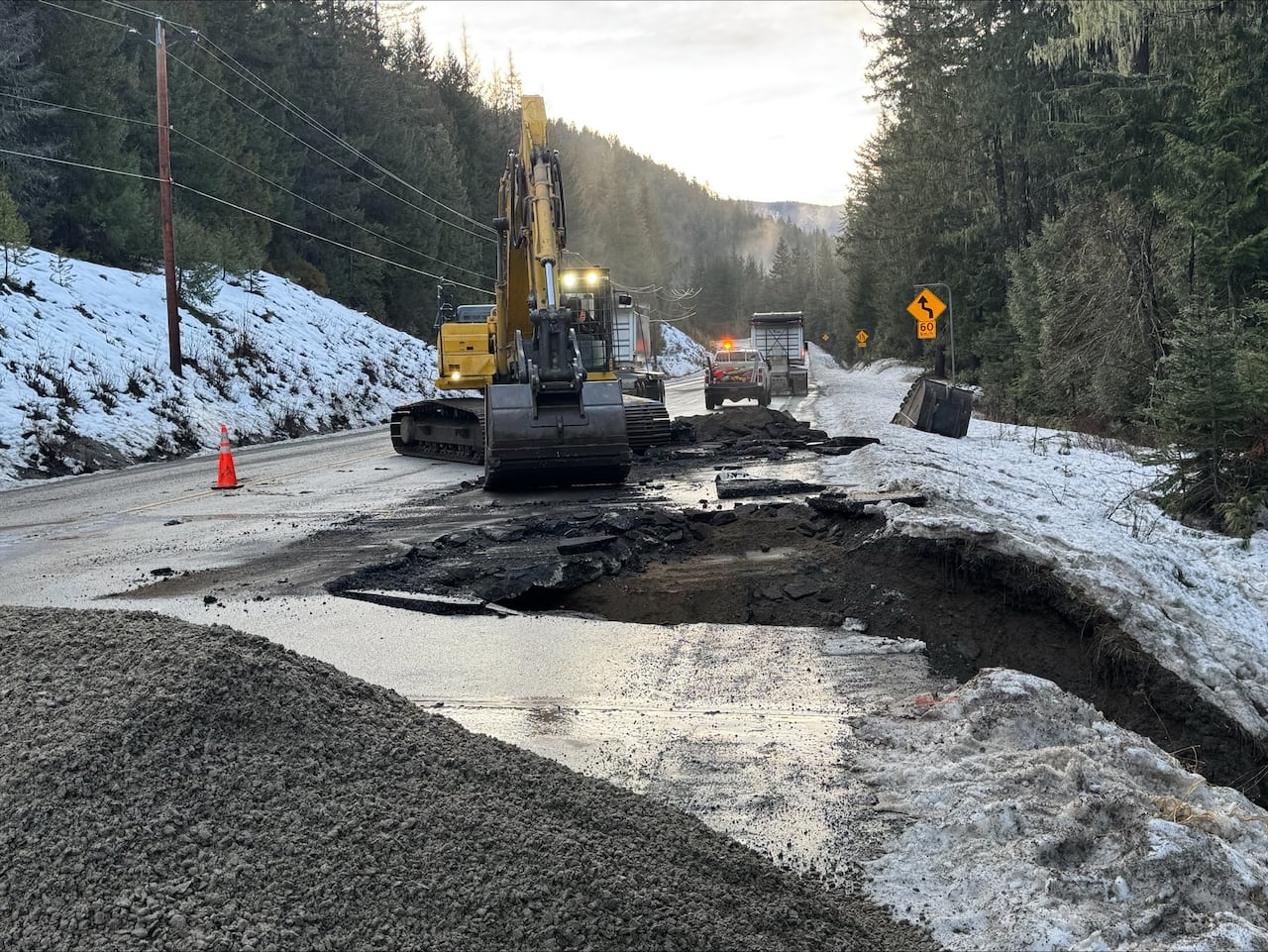 Maintenance contractor crews working hard on emergency repair along a highway.