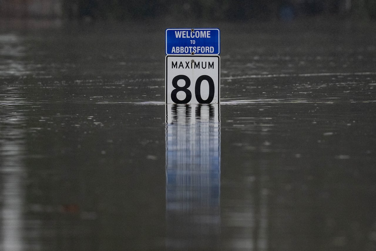 A Highway 1 speed limit sign pokes out from the floodwaters.