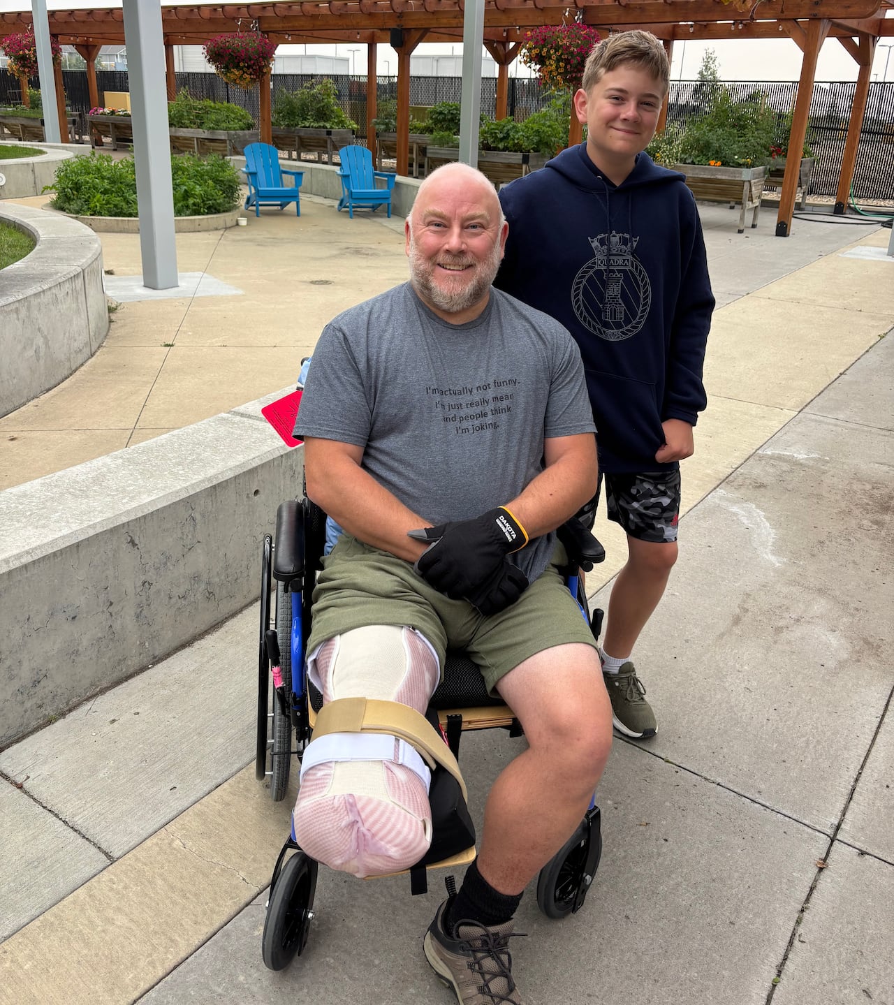 A man in a wheelchair and son look at the camera. 