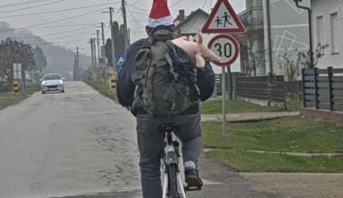 A man in Croatia was riding a bike and was carrying a small pig in his backpack