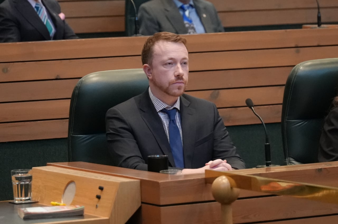 People sitting behind desks in a legislative assembly.