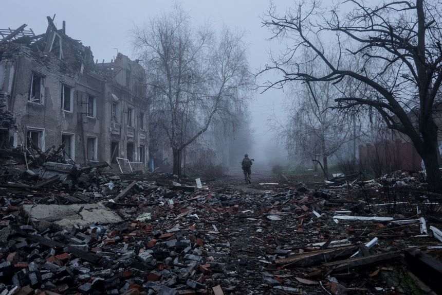 A Ukrainian serviceman walks near apartment buildings damaged by a Russian military strike in the frontline town of Kostiantynivka in Ukraine's Donetsk region, on November 28.
