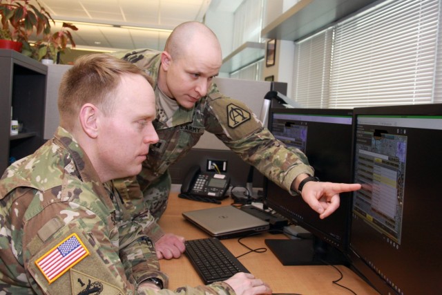 Capt. Doug Williams, right, and Capt. Jake Singleton review the Joint Battle Command – Platform’s new interactive multimedia instruction software in January at Aberdeen Proving Ground, Maryland. The software will allow Soldiers to train on the...
