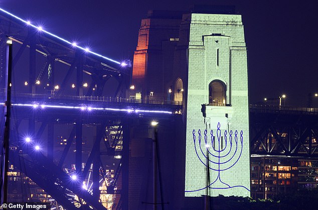 SYDNEY, AUSTRALIA - DECEMBER 31: An image of a menorah is projected onto the pylons of the Sydney Harbour Bridge during New Year's Eve celebrations on December 31, 2025, in Sydney, Australia. The projection was in tribute to the 15 victims of the Bondi Beach terror attack on December 14, 2025. (Photo by Izhar Khan/Getty Images)