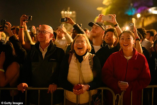 SYDNEY, AUSTRALIA - DECEMBER 31: People enjoy the New Year's Eve firework displays at Opera House on December 31, 2025 in Sydney, Australia. Thousands turned out to celebrate New Year's Eve in Sydney, as the Harbour Bridge lit up with fireworks. (Photo by George Chan/Getty Images)