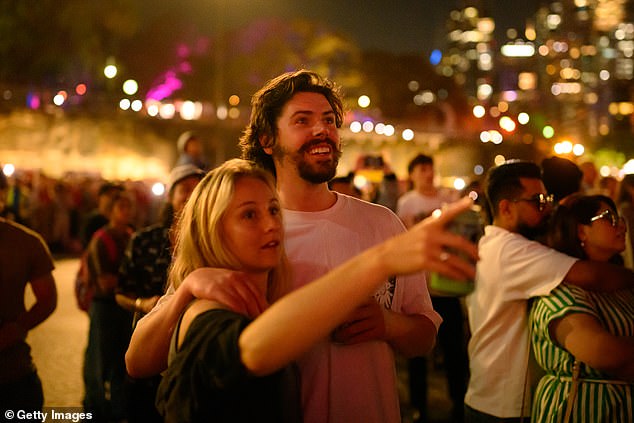 SYDNEY, AUSTRALIA - DECEMBER 31: People enjoy the New Year's Eve firework displays at Opera House on December 31, 2025 in Sydney, Australia. Thousands turned out to celebrate New Year's Eve in Sydney, as the Harbour Bridge lit up with fireworks. (Photo by George Chan/Getty Images)