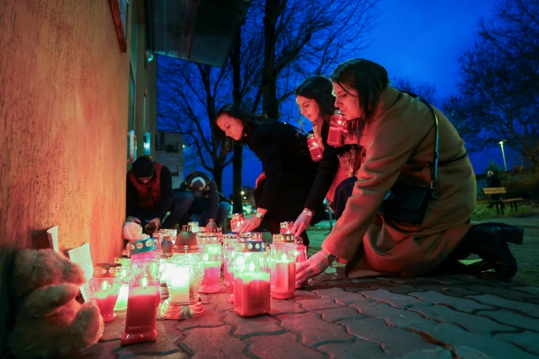Women light candles at a makeshift memorial outside the Zagreb school where the stabbing happened