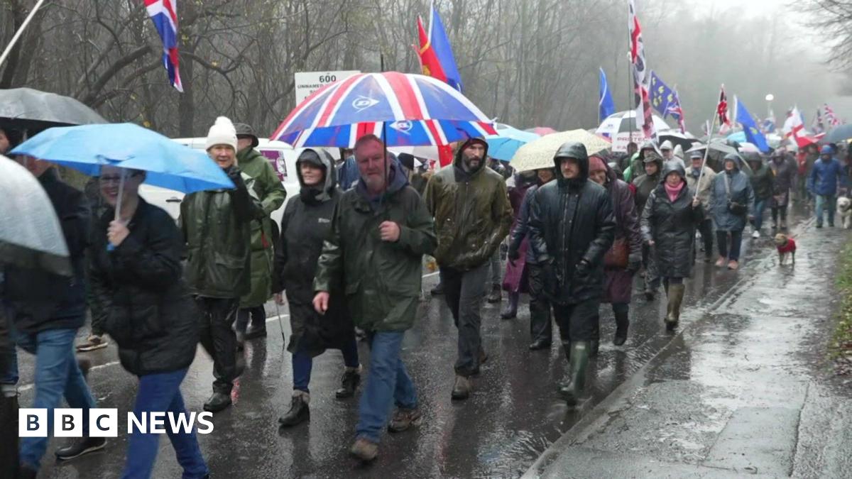 People protest in the rain.