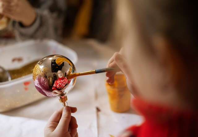 A child decorates a Christmas ornament.