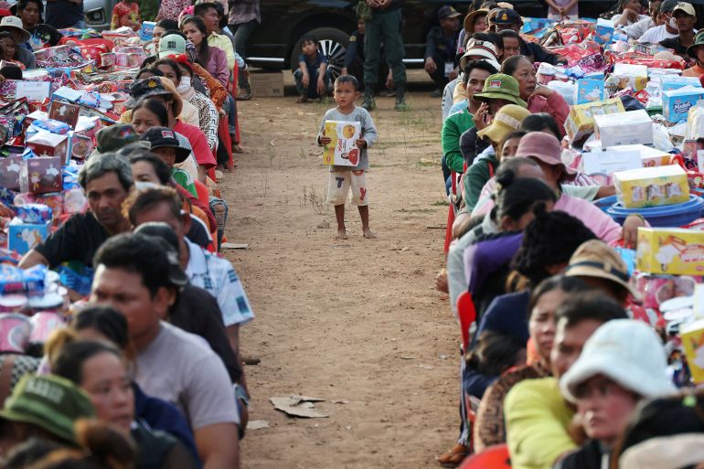 A boy holding a supply stands among people waiting to collect supplies at Batthkav refugee camp, amid clashes between Thailand and Cambodia along a disputed border area, in Chong Kal, Oddar Meanchey Province, Cambodia, December 12, 2025. REUTERS/Kim Hong-Ji TPX IMAGES OF THE DAY