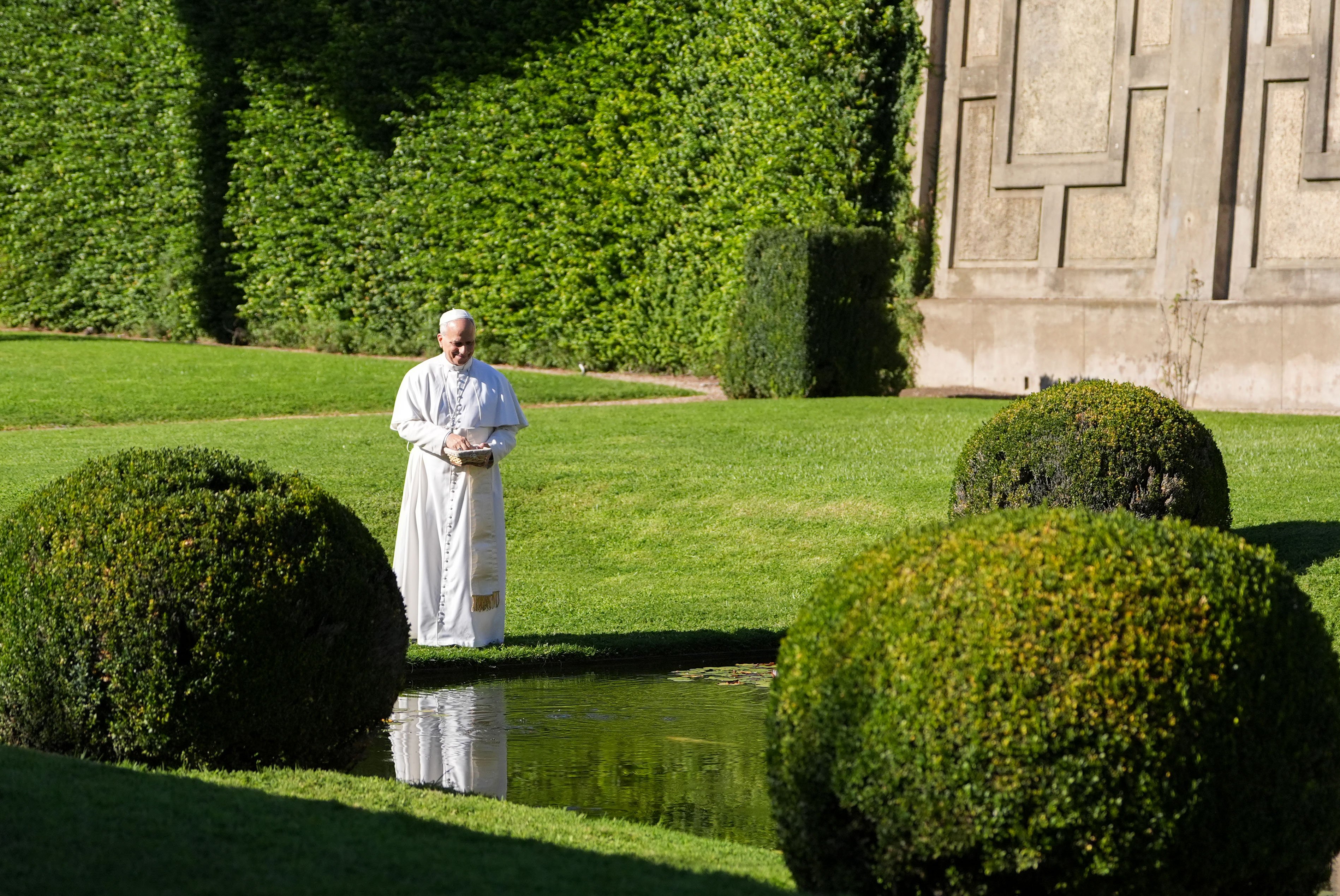 Pope Leo feeds the fish at the Borgo Laudato Si'