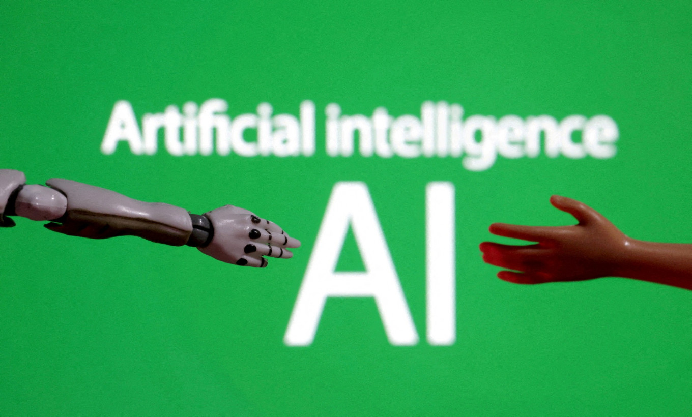 Words reading &ldquo;Artificial intelligence AI&ldquo;, miniature of robot and toy hand are pictured in this illustration created on Dec. 14, 2023.
