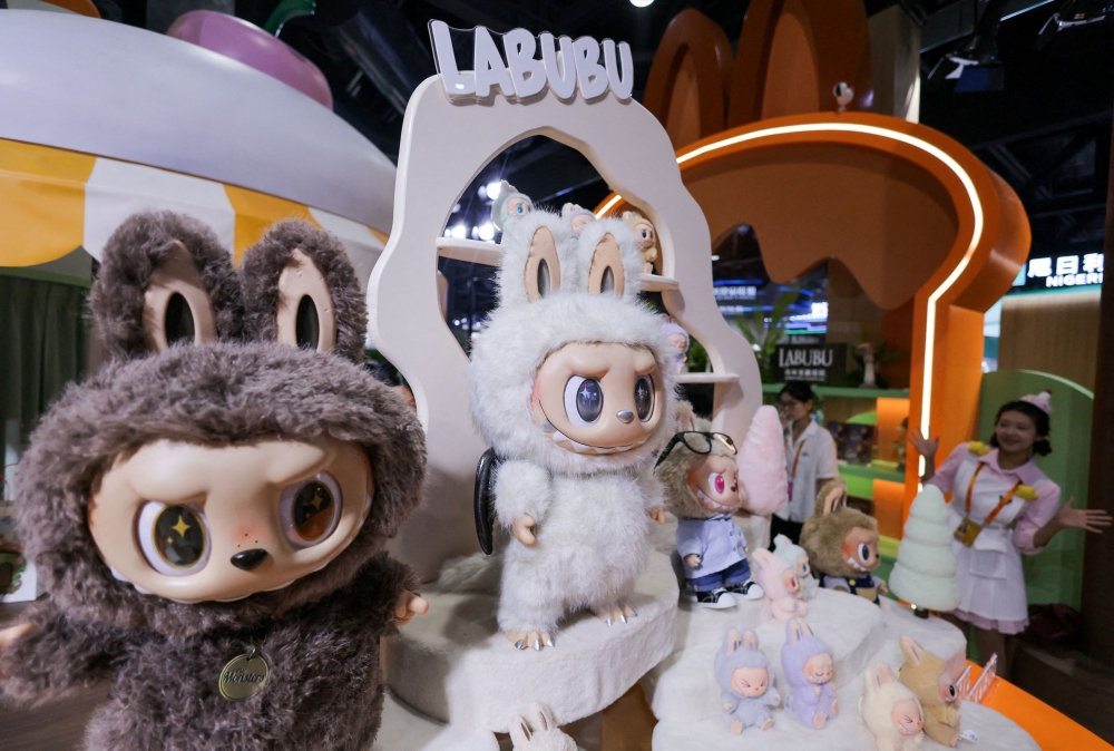 An employee gestures next to Labubu toys on display at Pop Mart’s booth at China International Fair for Trade in Services (CIFTIS) in Beijing, China, September 10, 2025. — Reuters pic 