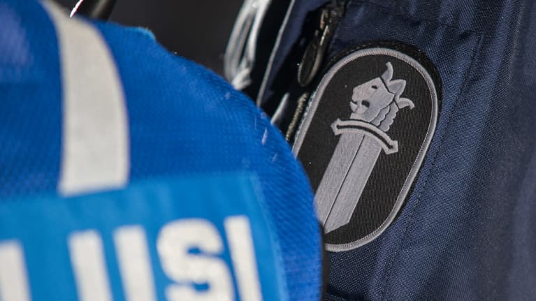 Poliisin hihamerkki ja poliisi-teksti selässä.
