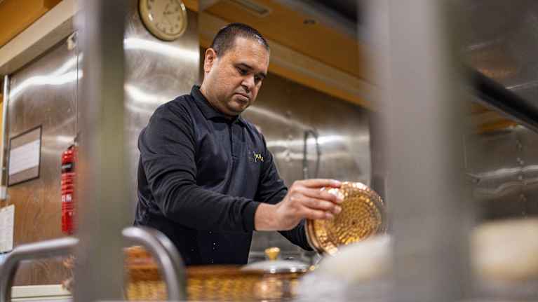 Keittiöapulainen Bhavesh Patel siivoaa astioita ravintolan keittiössä.