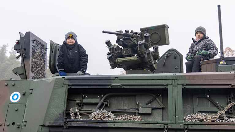 Kaksi poikaa kuljetuspanssariajoneuvon XA-360 päällä.