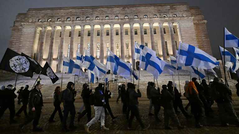 The Suomi herää march passes by the Finnish Parliament Building. 