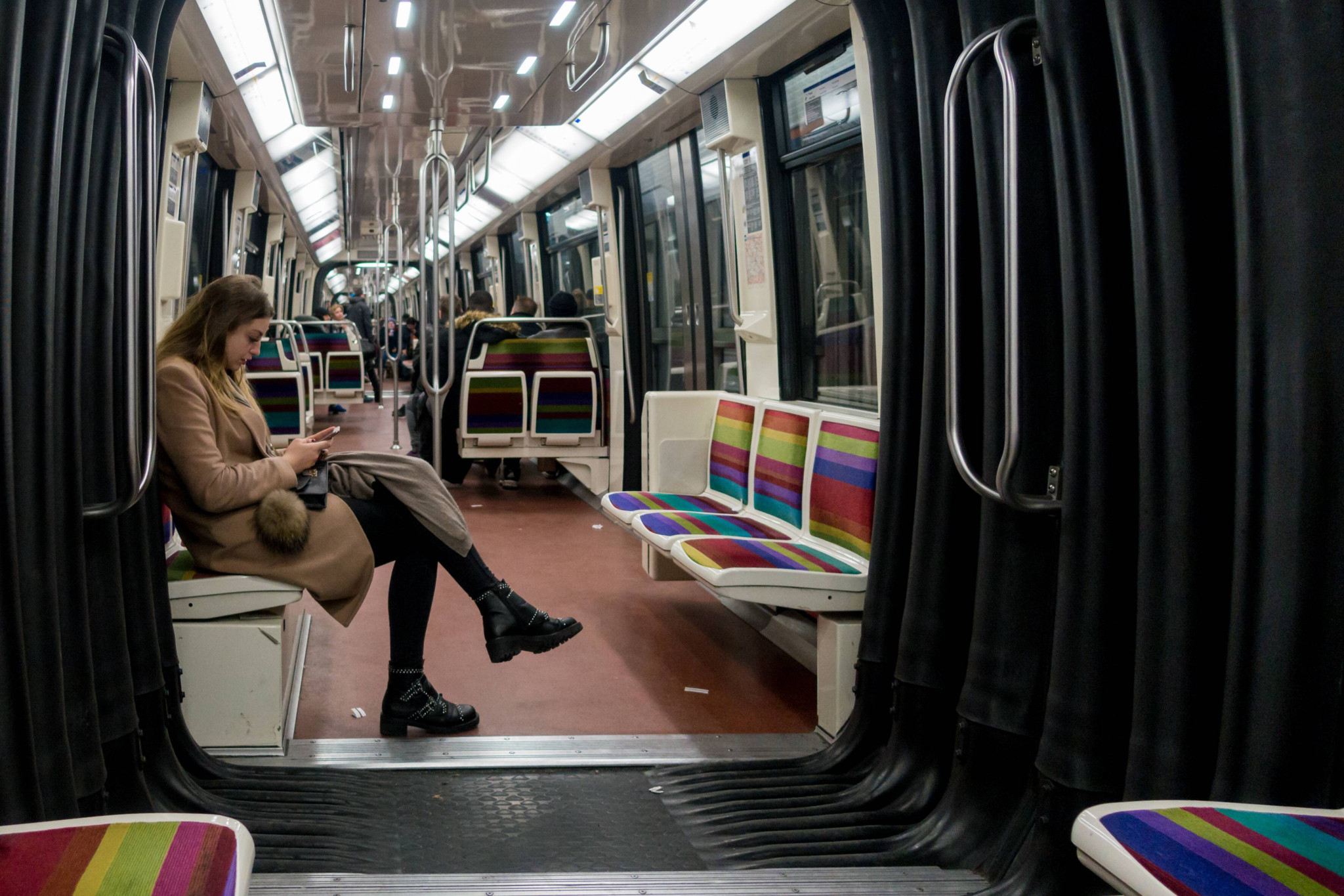 Frau sitzt mit Handy in einem Zug der Metrolinie 1 in Paris, Januar 2018.