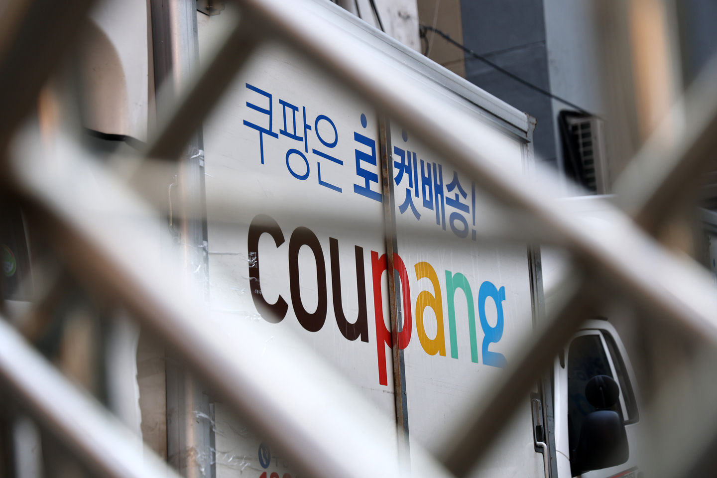 A Coupang delivery truck is seen through a fence in one of the e-commerce company's logistics centers in Seoul on Dec. 7. [YONHAP]