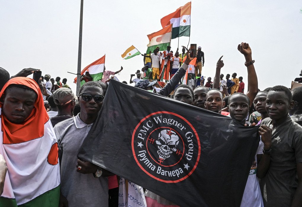 Men hold a flag bearing the logo of Wagner outside the Niger and French airbase in Niamey on September 2, 2023 (Source: AFP via Getty Images)