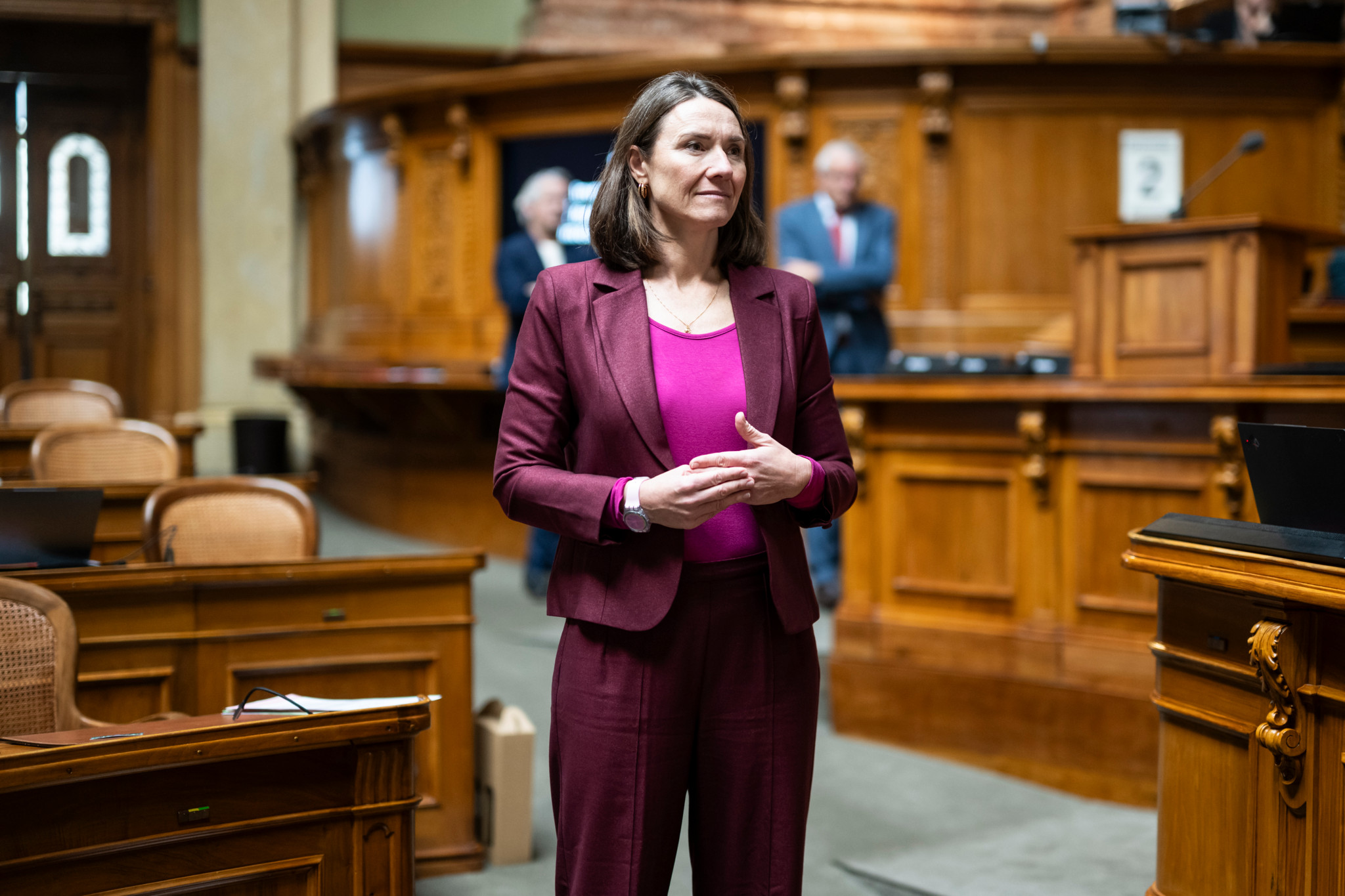 Sophie Michaud Gigon écoutant un discours lors de la session d’hiver des conseils fédéraux à Berne, vêtue d’un costume bordeaux.