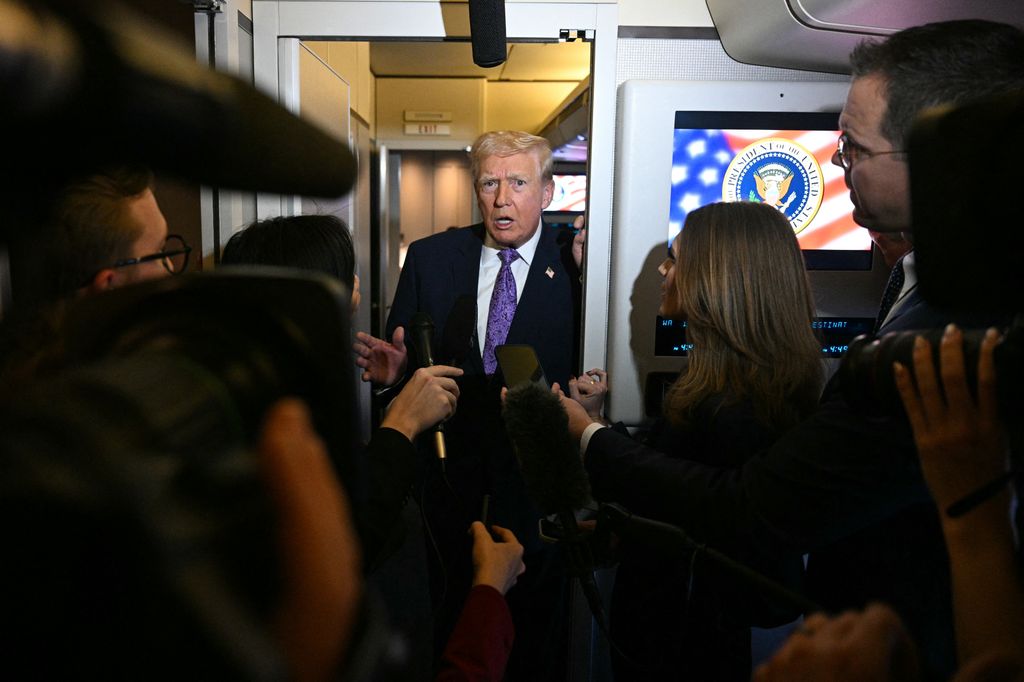 US President Donald Trump speaks to journalists aboard Air Force One while travelling from Palm Beach International Airport to Joint Base Andrews on his return to Washington, DC, on November 30, 2025. President Trump and First Lady Melania Trump spent the Thanksgiving holiday in Mar-a-Lago