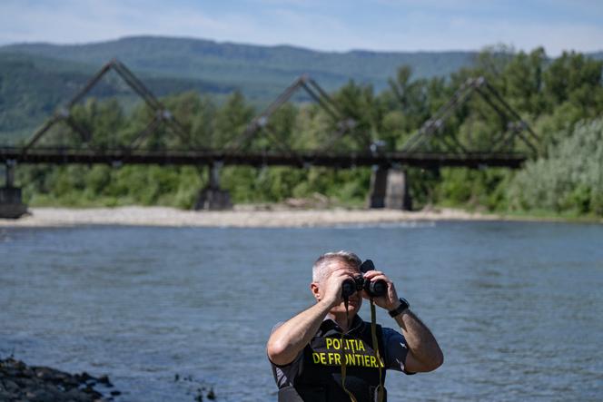 A Romanian border police officer on the banks of the Tisza River, at the border with Ukraine, near the Sighetu Marmatiei border crossing (in Romania), May 17, 2024.
