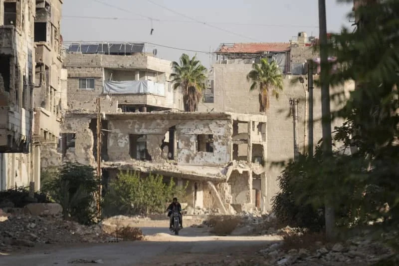 In the shattered streets of Harasta, where memories cling as stubbornly as the dust, survivors mark the first anniversary of Syria's new beginning — with hope in their pockets and trauma in their bones. Moawia Atrash/dpa