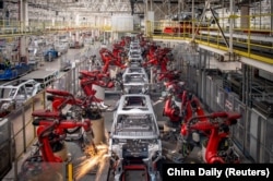 Robots work on vehicle chassis at a factory in China’s Zhejiang Province in April 2023.