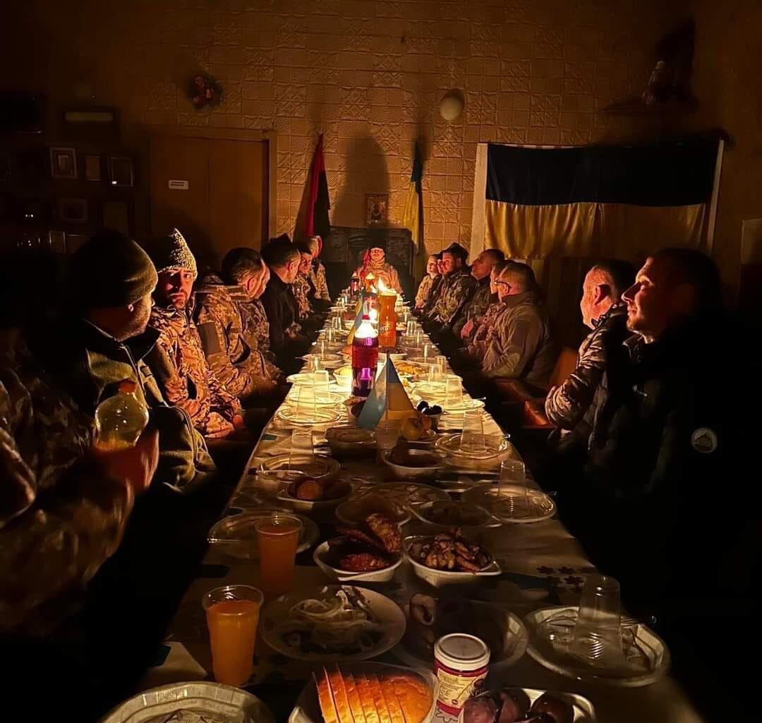Soldiers from the Ukrainian Army, gathered at a table for their Christmas Eve dinner.
